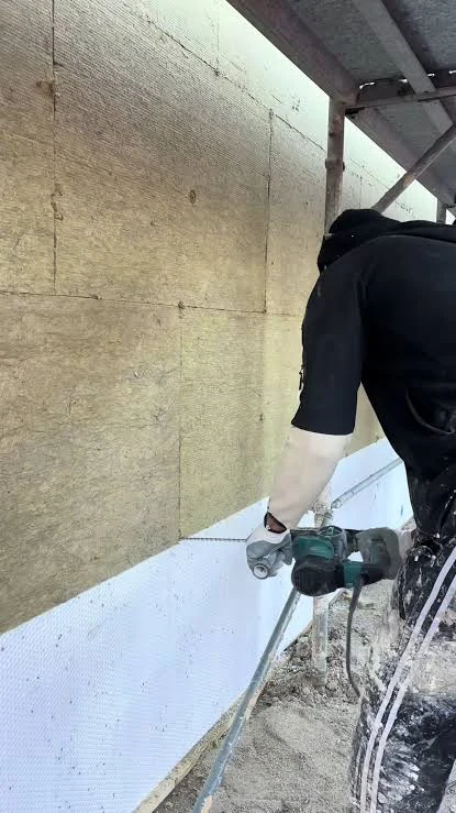 Lavorazione in cantiere davanti a pannelli in lana minerale