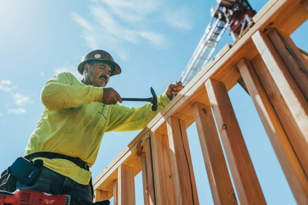 Operatore al lavoro su una struttura in legno; immagine illustrativa dei giunti da coordinare durante la posa